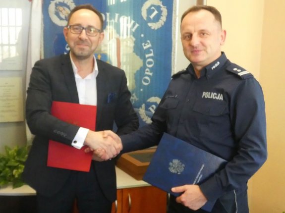 Wójt Gminy Tarnów Opolski i Komendant Miejski Policji w Opolu podają sobie dłoń na znak zawartego porozumienia